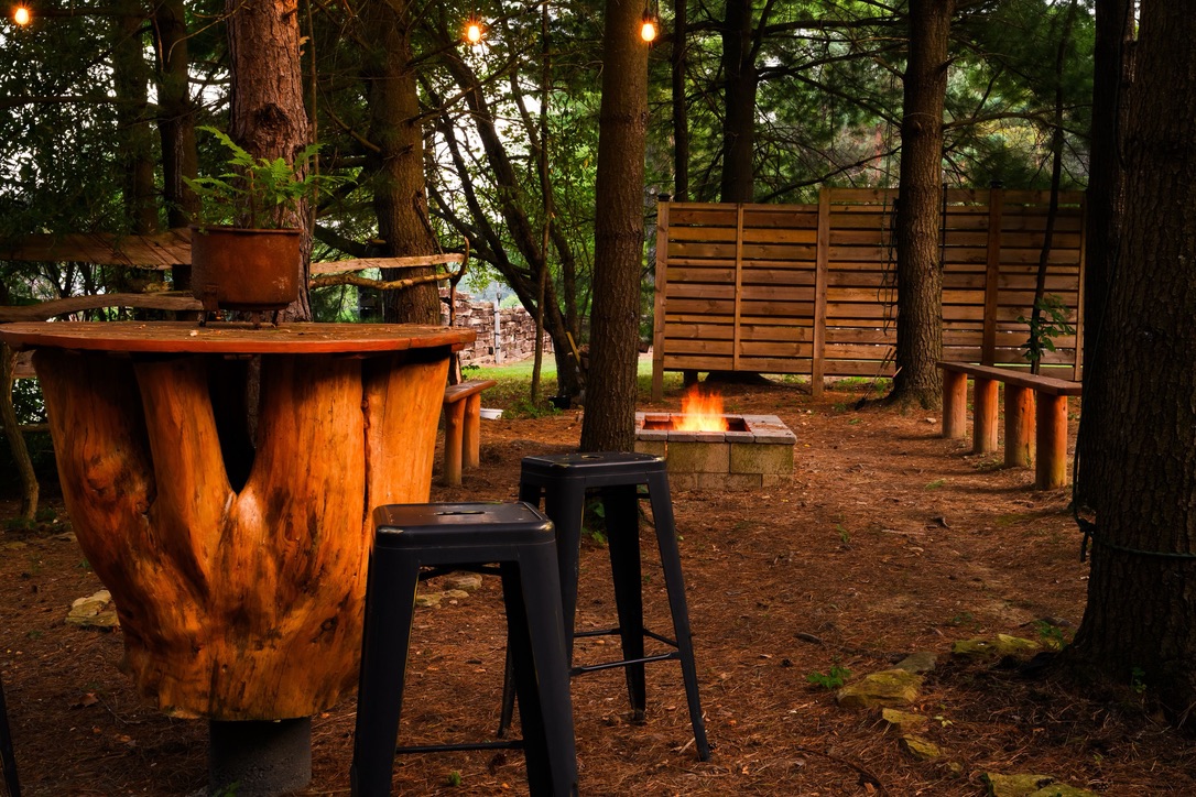 Shire Villa's timber outdoor bar and fire pit among the trees